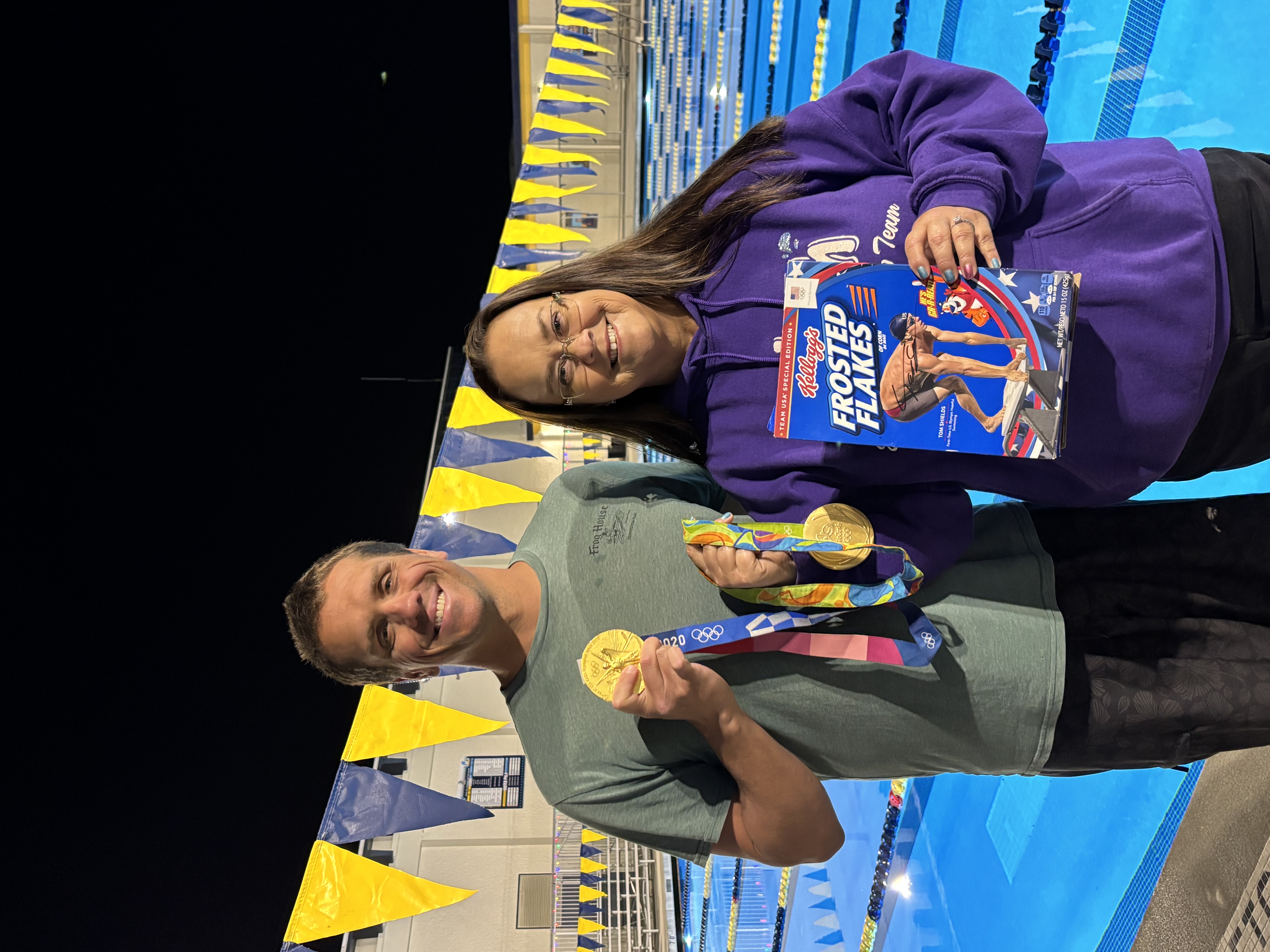 Tom with Olympic medals poolside at night