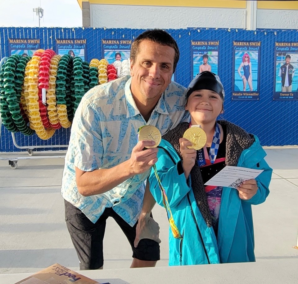 Tom with young athlete and Olympic medals